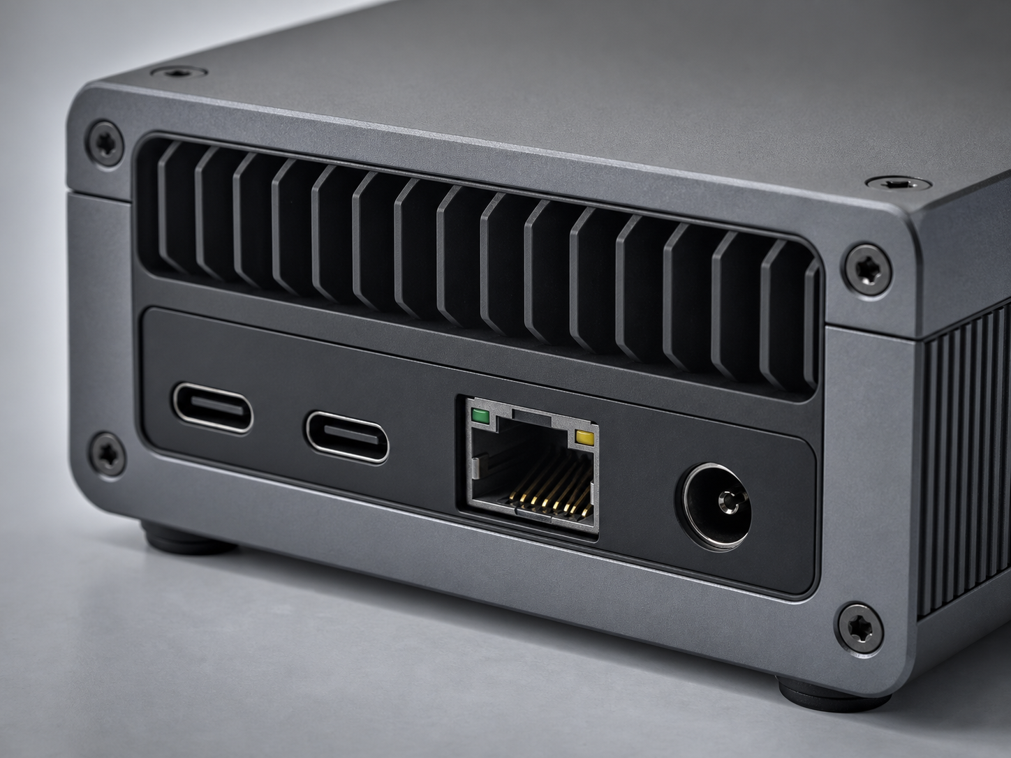 Closeup of gpuvera rear I/O: USB-C, Ethernet, DC power and a machined cooling grille — concept render, pre-production.